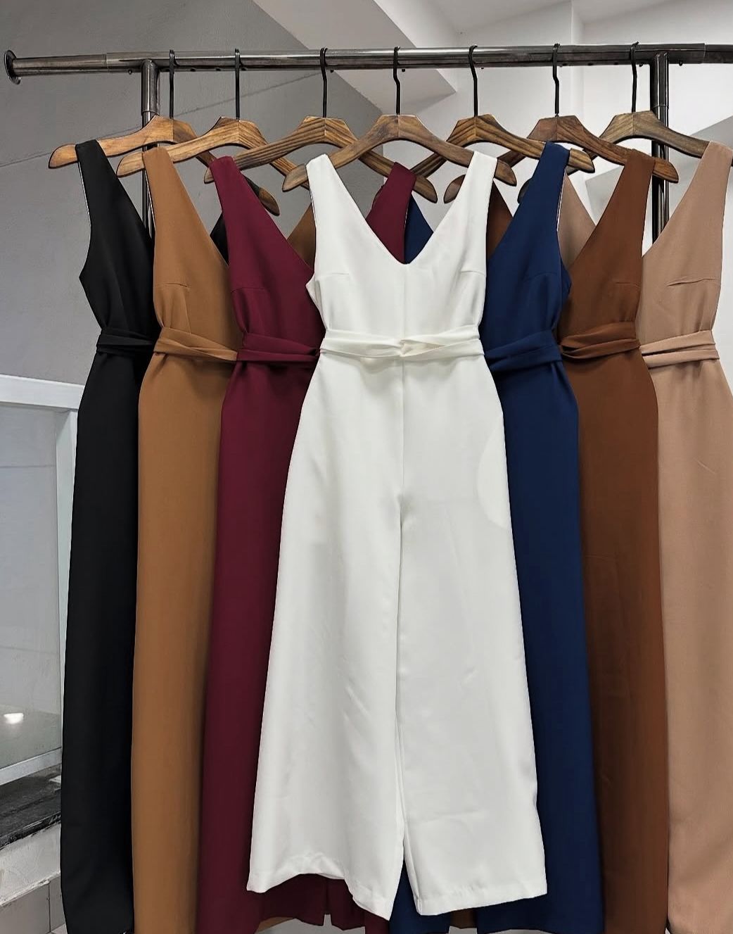 Modelo usando o Macacão Longo de Alfaiataria [cor] com decote V e amarração na cintura.