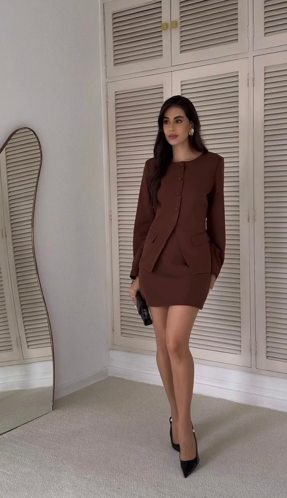 Modelo usando o Conjunto de Alfaiataria Feminino com saia curta e blazer na cor marrom.